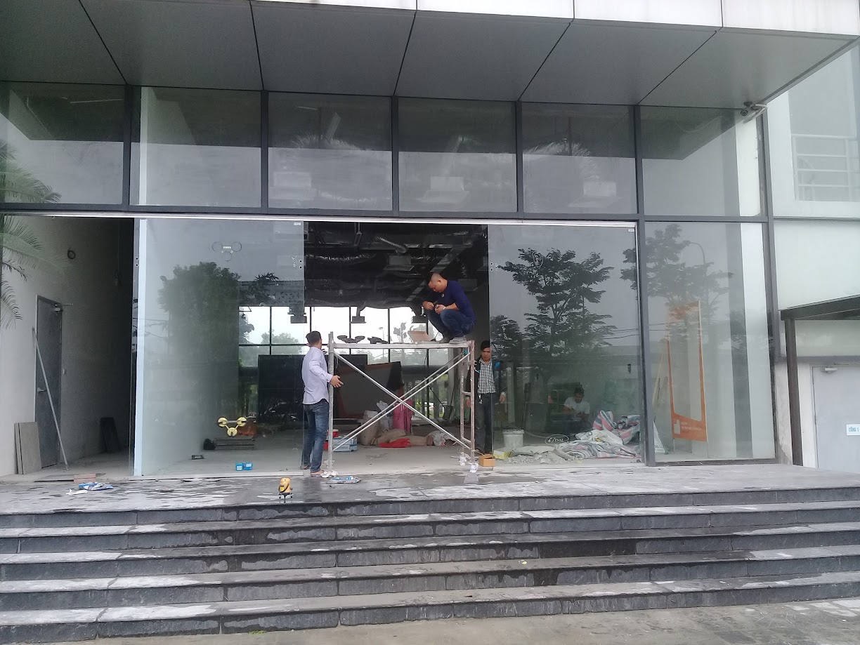 Thi công lắp đặt cửa kính cường lực mặt tiền tòa nhà văn phòng